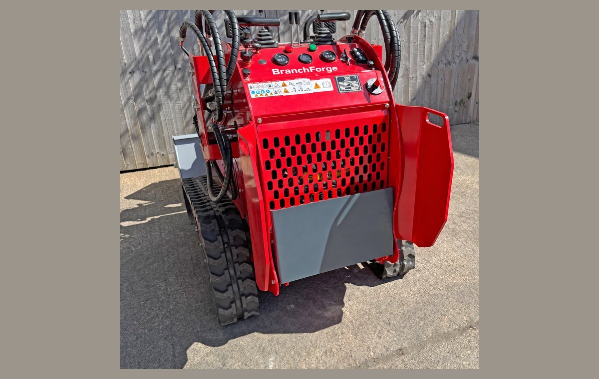Rear view of the mini skid steer showing the engine bay and tracks